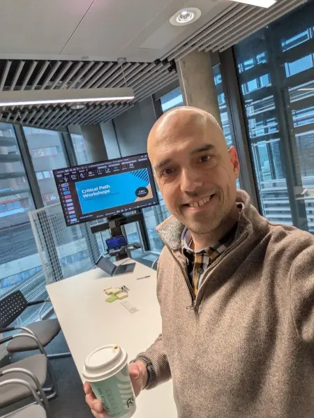 Scott at a workshop holding a coffee